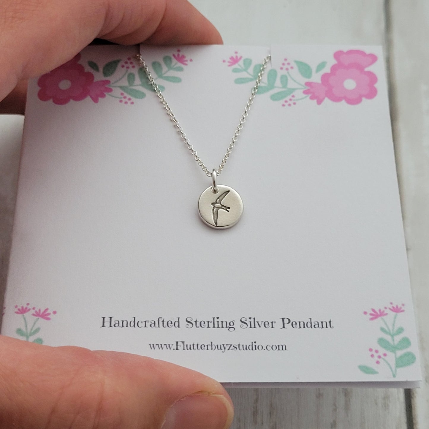 Round bird silver pendant necklace on presentation printed card