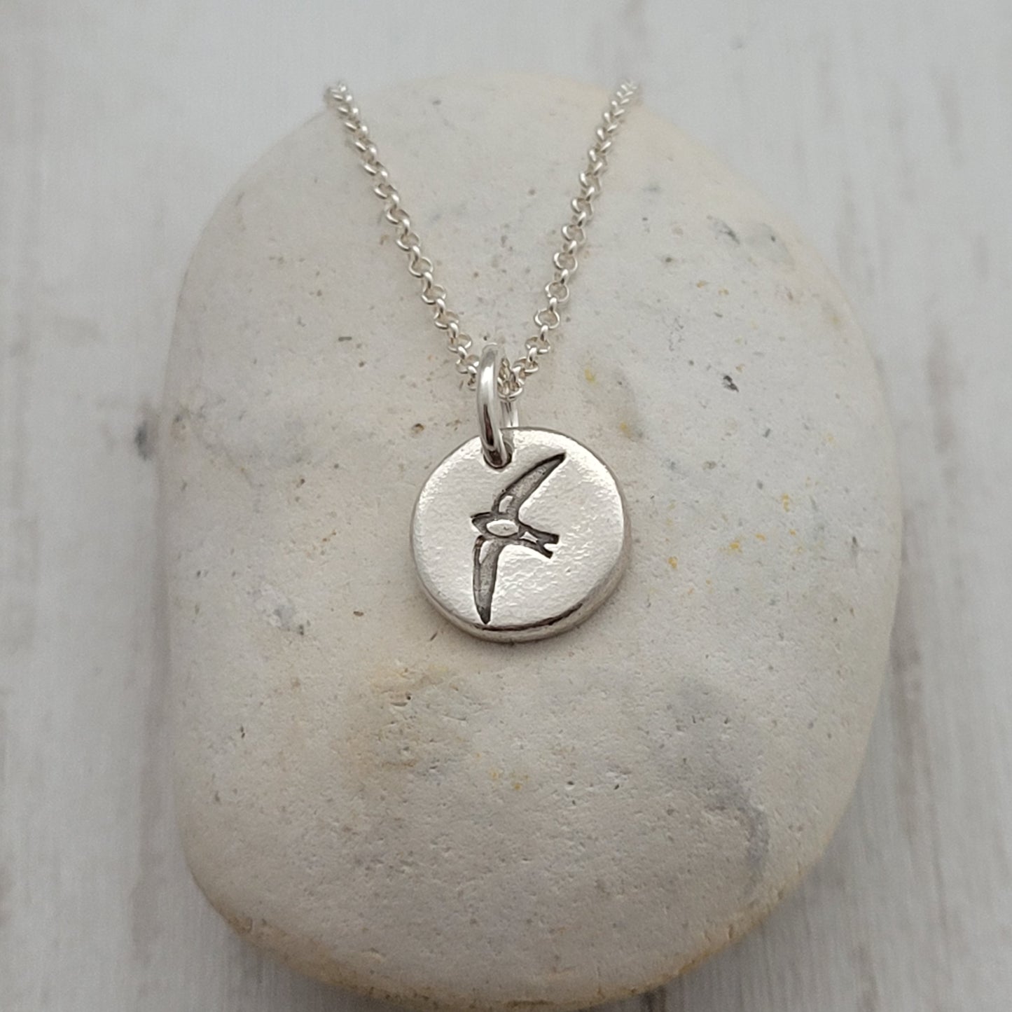 Sterling silver round swallow bird pendant on a stone