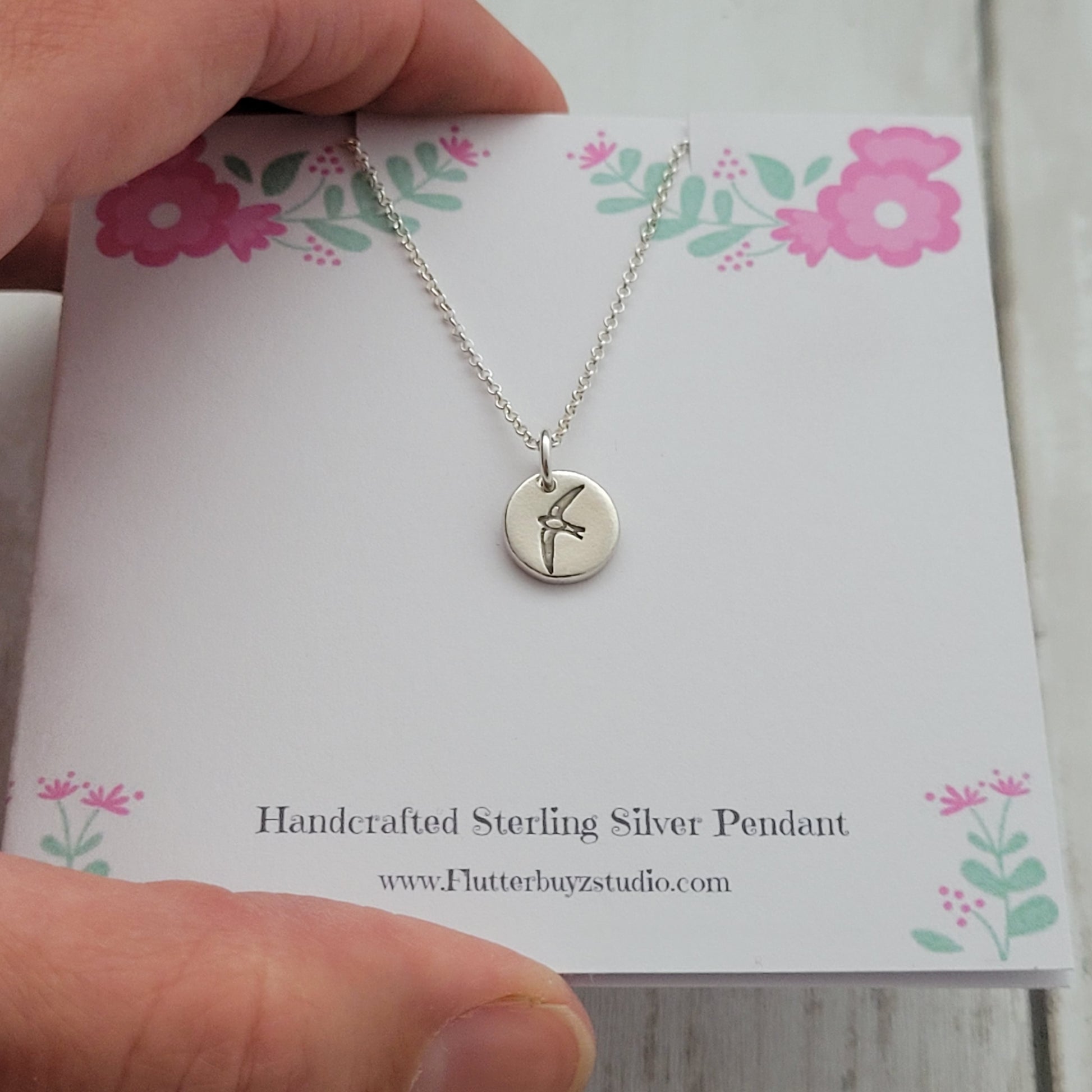 Round bird silver pendant necklace on presentation printed card