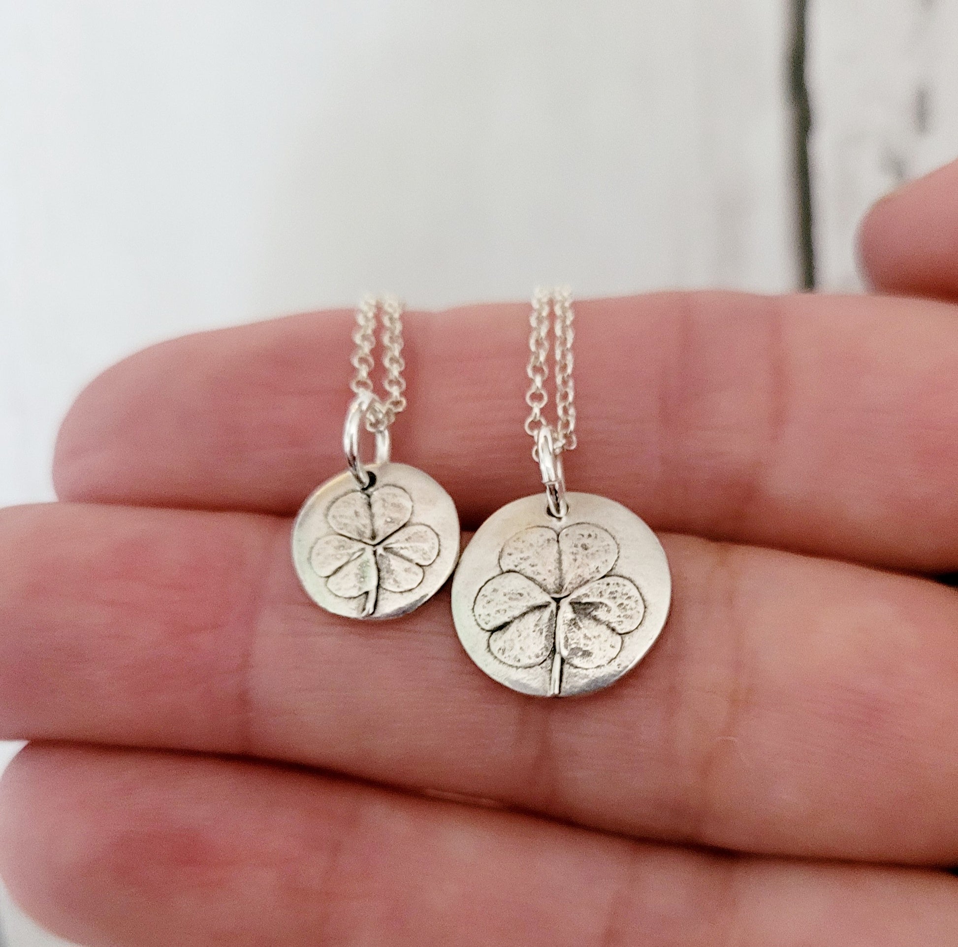 Tiny and mini shamrock leaf pendants on chains held