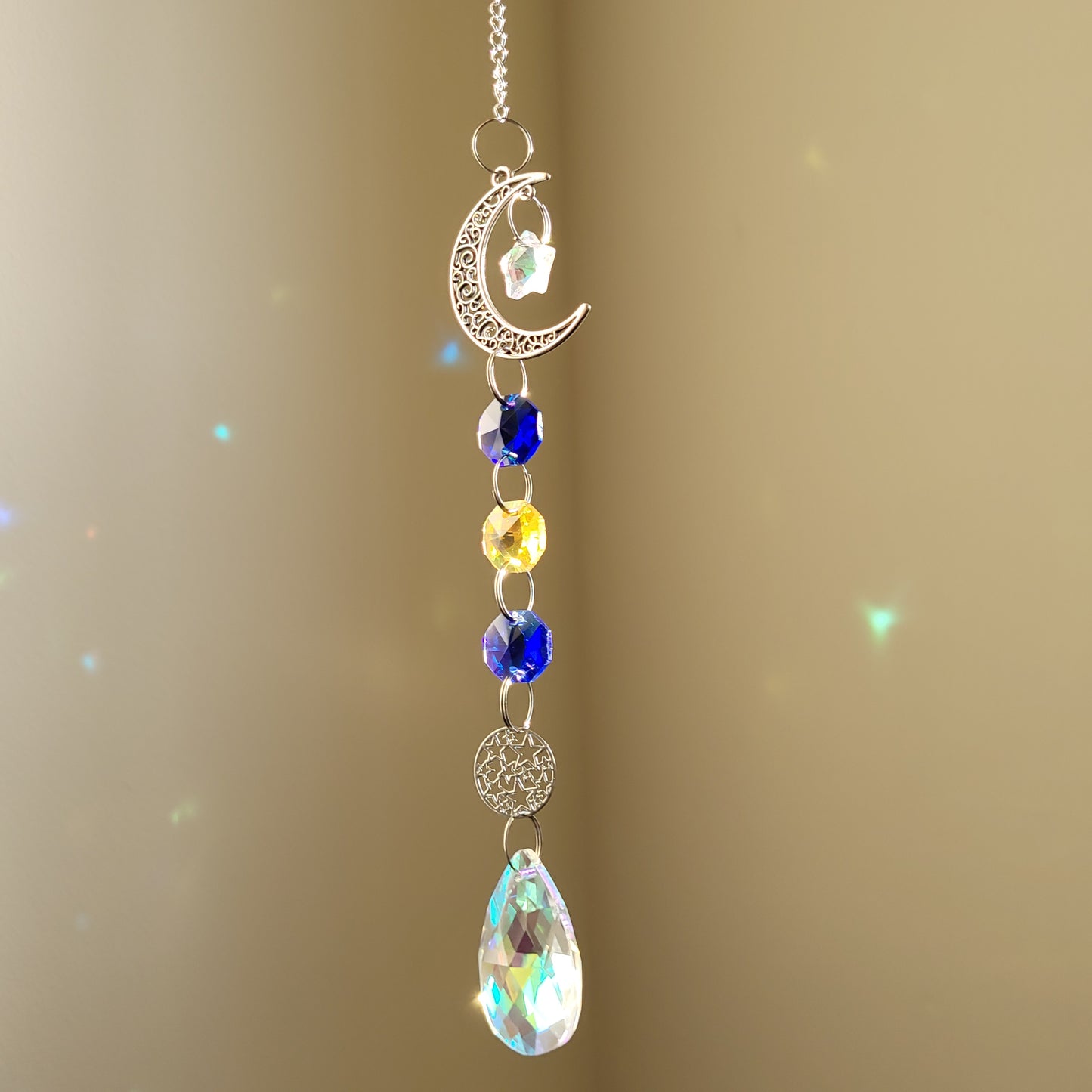 moon and star suncatcher with colourful blue and yellow crystals on a beige background