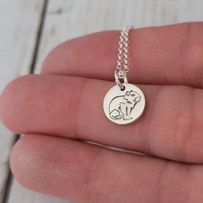 tiny 1cm capybara pendant being held in hand