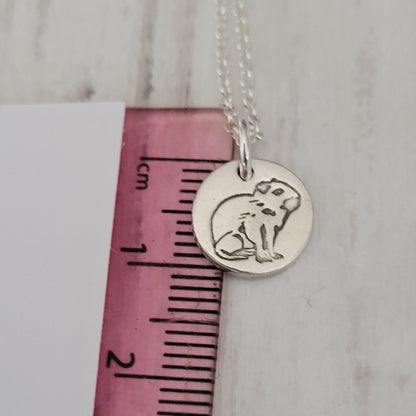 capybara round pendant against pink ruler