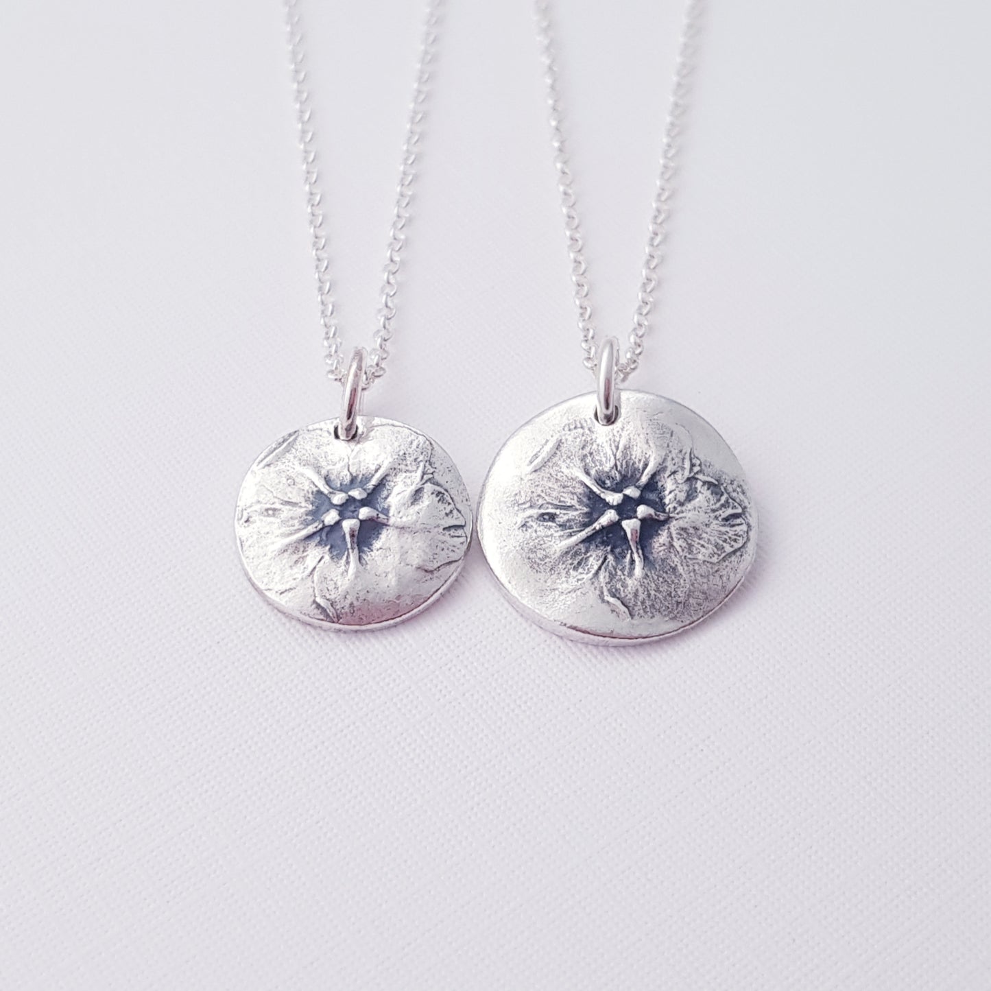 two botanical flower pendants on white background.