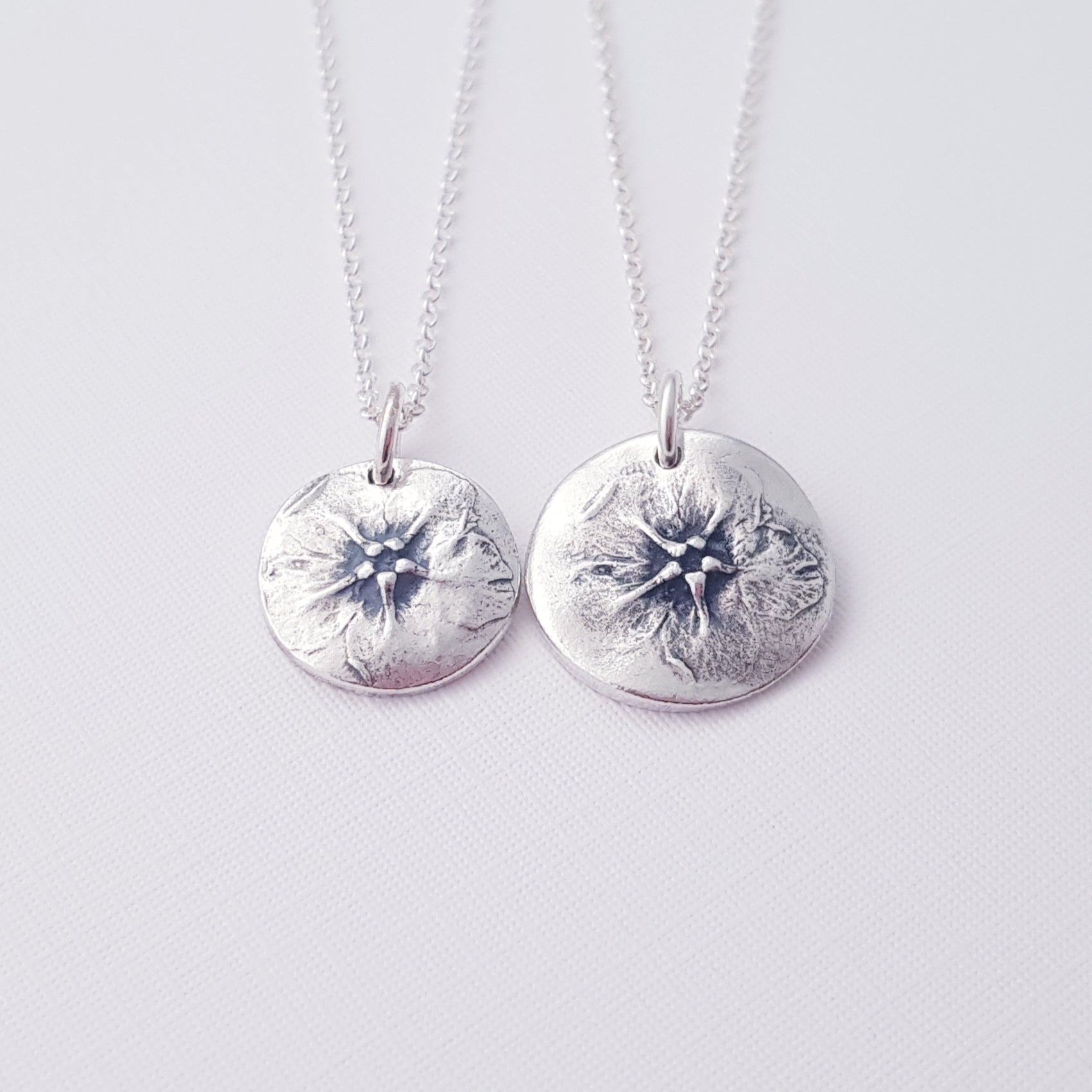 two botanical flower pendants on white background.