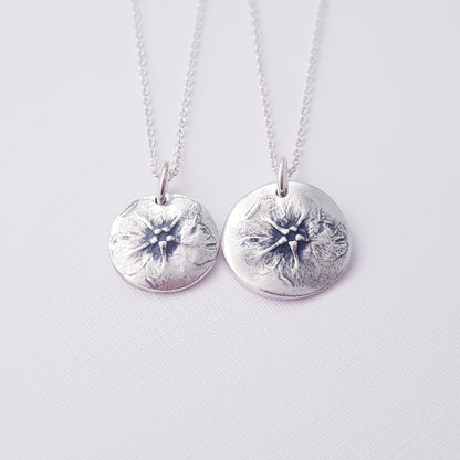 two botanical flower pendants on white background.