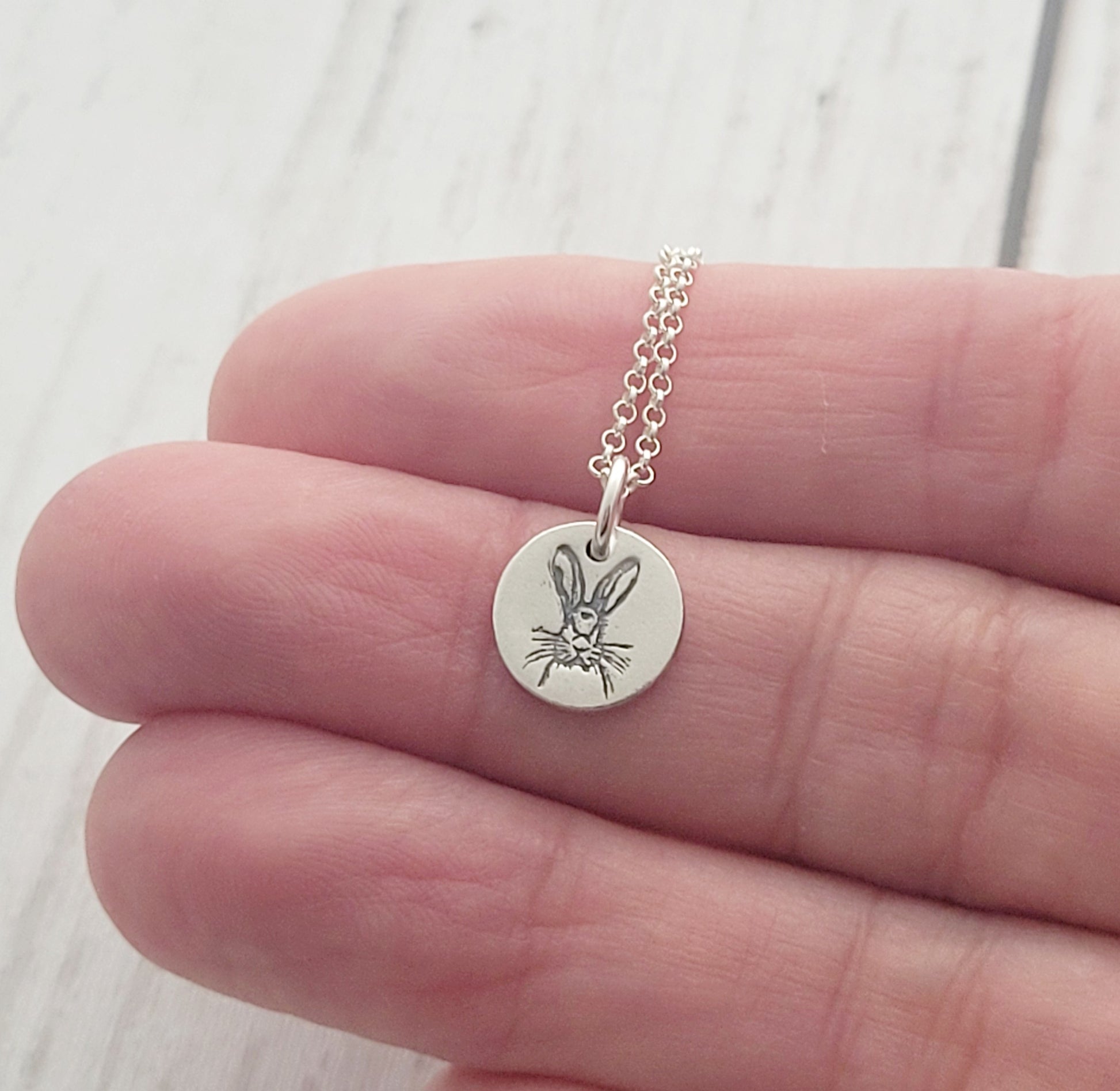round hare necklace held in hand