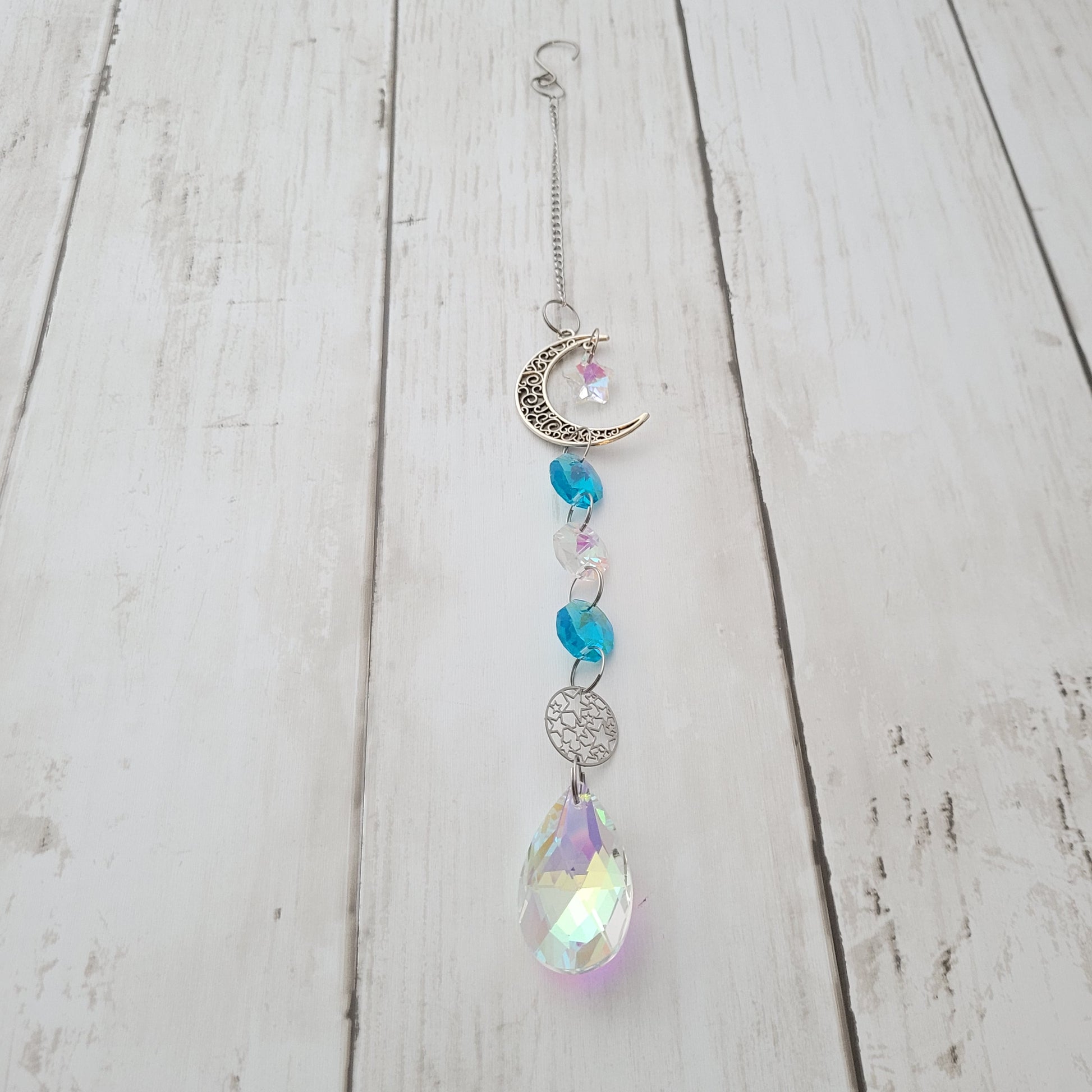 Decorative moon hanging  suncatcher ornament with crystals on a wooden surface