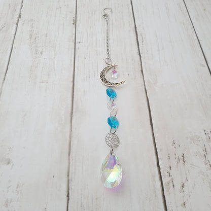 Decorative moon hanging  suncatcher ornament with crystals on a wooden surface