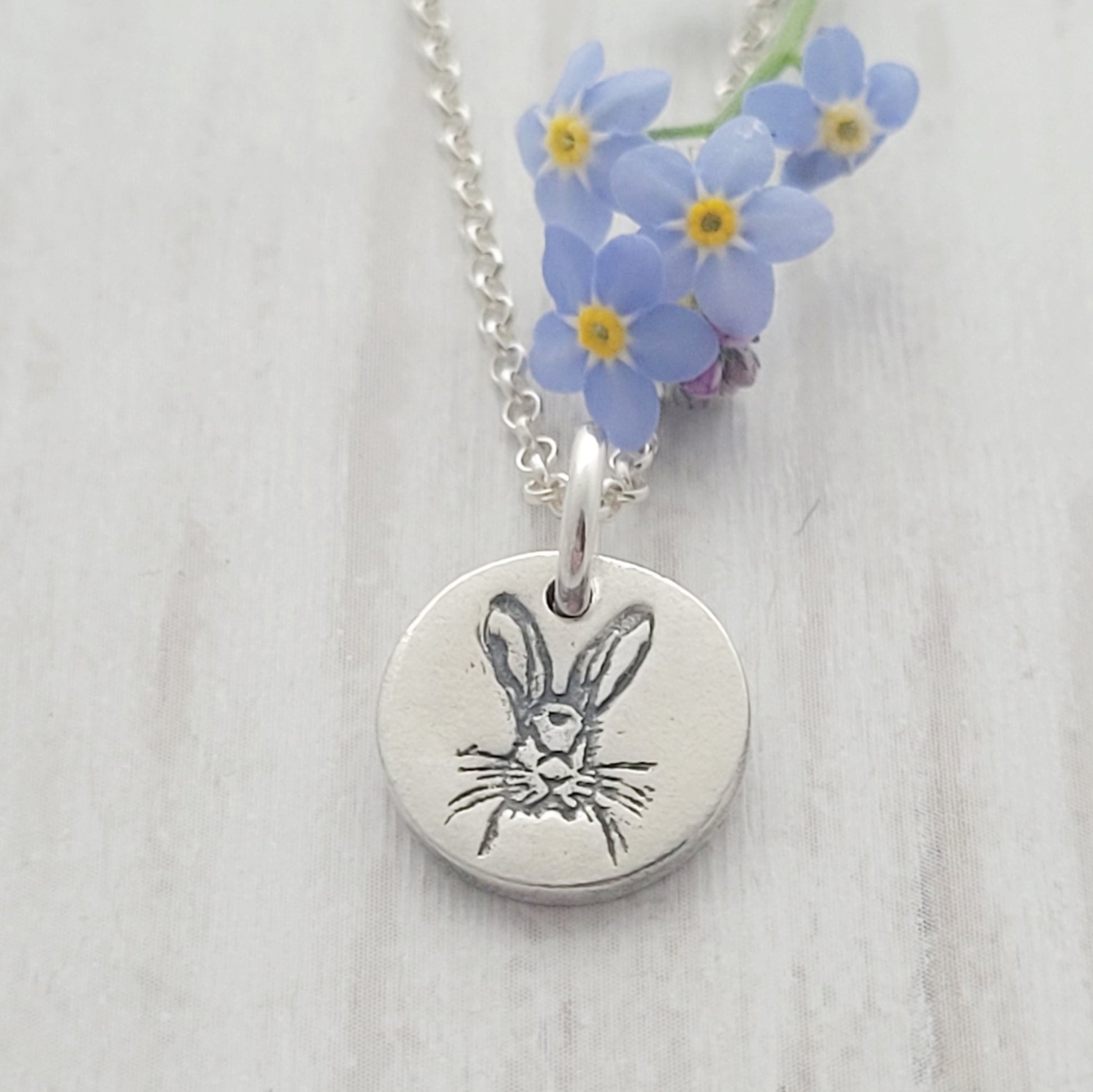 round silver hare necklace with forget me not flowers