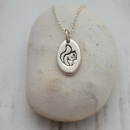 Silver necklace with a pendant on a stone surface