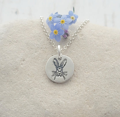 round animal pendant with blue flowers on white stome background