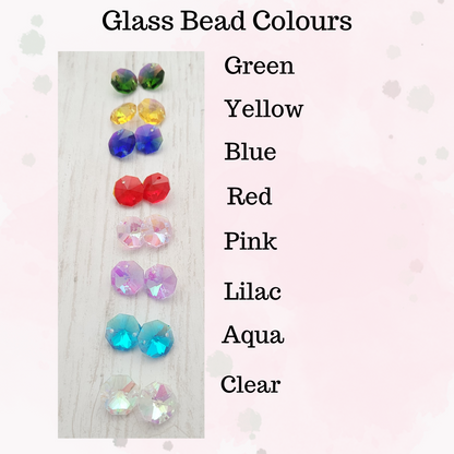 Glass beads in various colours on a textured surface with colour names listed.