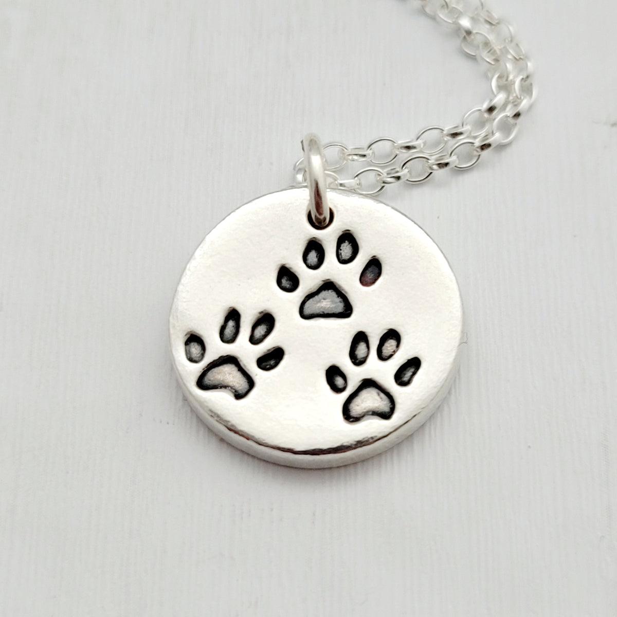 round pendant with three tiny paw prints